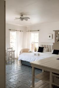 a bedroom with a large bed and a table at Summer House B&B in Gqeberha