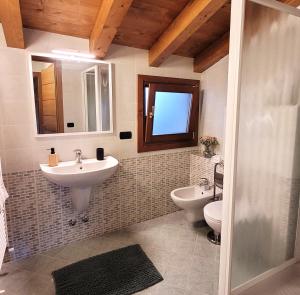 a bathroom with two sinks and a toilet and a window at L'Antico Fienile Mountain Lake Iseo Hospitality in Fonteno +26 photos