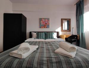 a bedroom with a large bed with two towels on it at Mega Residence in Târgovişte