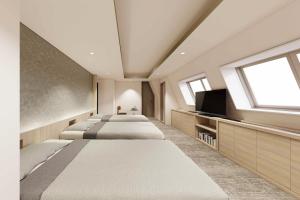 a bedroom with four beds and a flat screen tv at the b sangenjaya in Tokyo