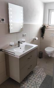 a white bathroom with a sink and a toilet at Unterkunft-Uettingen in Uettingen +8 photos