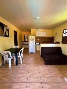a living room with a table and a kitchen at Vila Itacimirim in Itacimirim