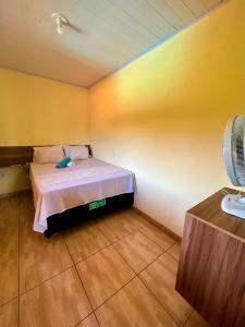 a bedroom with a bed in a room with yellow walls at Vila Itacimirim in Itacimirim +34 photos