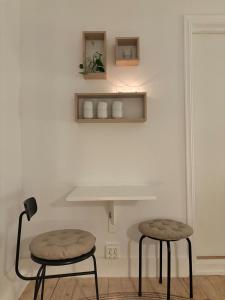 two stools in a room with a white wall at Cozy Studio - 9 min Walk from Oslo Central Station in Oslo