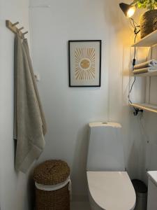 a bathroom with a toilet and a picture on the wall at Cozy Studio - 9 min Walk from Oslo Central Station in Oslo +3 photos