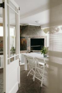 a white table and chair in a room with a fireplace at Summer House B&B in Gqeberha