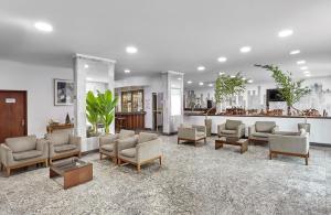 a waiting room with couches and chairs and a bar at Hotel Nacional Inn Limeira in Limeira
