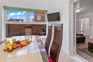 a dining room table with a tray of fruit on it at Ideal Budget Contractor Stay - 4B Home w en-suites in Great Sankey