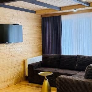 a living room with a couch and a tv at Kobuleti Seaside Cottage in Kobuleti