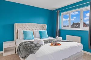 a blue bedroom with a bed with a tray of food on it at Ideal Budget Contractor Stay - 4B Home w en-suites in Great Sankey