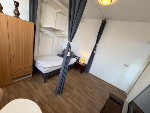 an overhead view of a small room with a bed and curtains at Rustige, zelfstandige studio- uitsluitend 1 persoon in Dedemsvaart