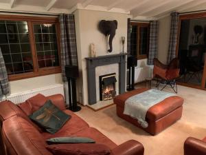 a living room with a couch and a fireplace at The Hermitage in Penrith