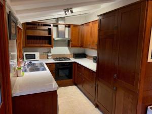 a small kitchen with wooden cabinets and a sink at The Hermitage in Penrith
