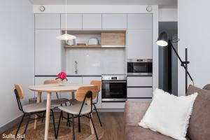 a kitchen and dining room with a table and chairs at Mónaco Suites & Garden in Ponta Delgada +23 photos
