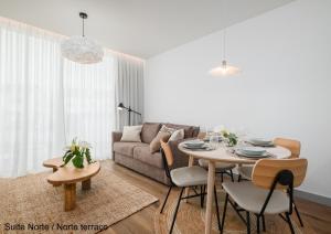 a living room with a table and a couch at Mónaco Suites & Garden in Ponta Delgada