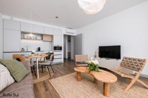 a living room with a couch and a table at Mónaco Suites & Garden in Ponta Delgada