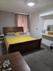 a bedroom with a large bed with a yellow blanket at The Royal Oak Hotel in Chapel en le Frith