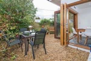 a patio with a table and chairs on a gravel floor at Ty Draw in HAW