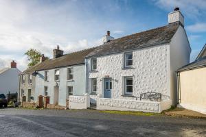 a white house with a black roof on a street at Ty Draw in HAW
