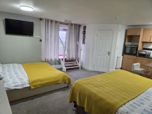 a hotel room with two beds and a television at The Royal Oak Hotel in Chapel en le Frith +19 photos