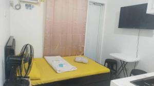 a small room with a yellow table and a sink at Jessa's Transient Studio with Balcony in Masbate