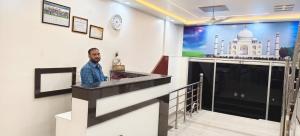 a man standing at a bar in a building at Hotel Sagar in Agra