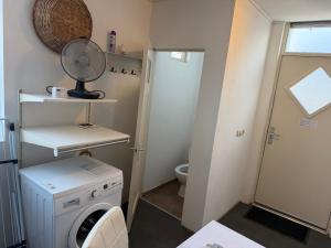 a small bathroom with a washing machine and a toilet at Rustige, zelfstandige studio- uitsluitend 1 persoon in Dedemsvaart +15 photos
