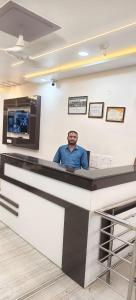 a man sitting at a bar in a room at Hotel Sagar in Agra