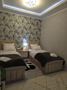 a bedroom with two beds and a wallpaper at Guest house 2 in Fergana