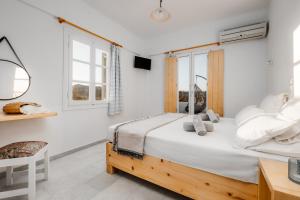 a white bedroom with a large bed and windows at Naxos Aethereal View in Kastraki
