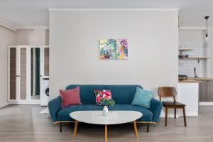a living room with a blue couch and a table at Gantiadi Holiday - Pool and Houses in Batumi