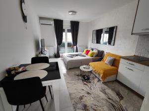 a living room with a couch and a table at Apartman BULEVAR1 sa garažom in Doboj