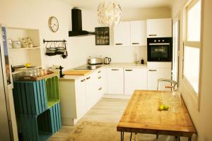 a kitchen with white cabinets and a wooden table at Stadthaus Ca Sa Batlessa in Arta in Artá +12 photos