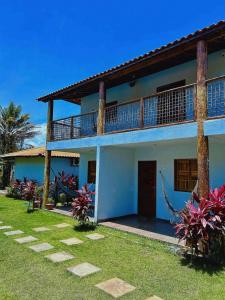 a blue and white house with a balcony at Vila Itacimirim in Itacimirim