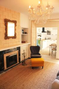 a living room with a fireplace and a chair and a mirror at Stadthaus Ca Sa Batlessa in Arta in Artá