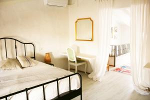 a bedroom with a bed and a desk with a mirror at Stadthaus Ca Sa Batlessa in Arta in Artá