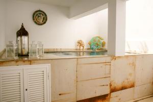 a kitchen with a white counter top with a clock on the wall at Stadthaus Ca Sa Batlessa in Arta in Artá