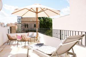 a patio with chairs and an umbrella on a balcony at Stadthaus Ca Sa Batlessa in Arta in Artá