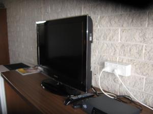 um monitor de computador sentado em cima de uma secretária em Darlot Motor Inn em Horsham