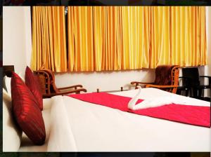 a bedroom with two beds with red and white sheets at Nature Quite in Vattavada