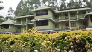 a green building with flowers in front of it at Nature Quite in Vattavada