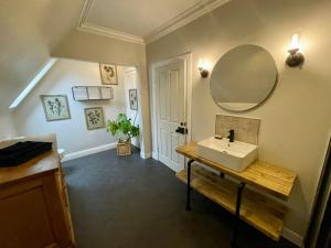 a bathroom with a sink and a mirror on the wall at Room 3, Wedale House in Stow