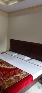 a bedroom with a bed with a red and white blanket at Hotel Sagar in Agra +19 photos