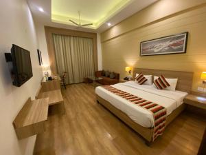 a hotel room with a bed and a television at Hotel KC Cross Road Panchkula in Panchkula