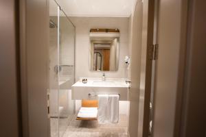 a bathroom with a sink and a shower with a mirror at Reiwa Business Hotel in Osmaniye +25 photos