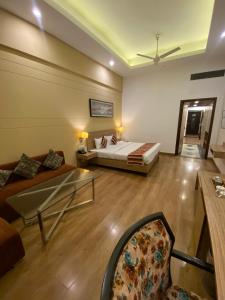 a hotel room with a bed and a couch at Hotel KC Cross Road Panchkula in Panchkula