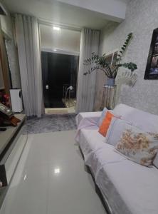 a living room with a white couch and a window at Ap bom descanso in Palhoça +5 photos