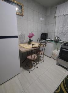 a kitchen with a table and chairs and a refrigerator at Ap bom descanso in Palhoça