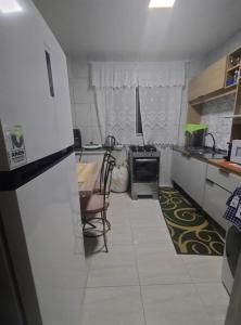 a kitchen with a refrigerator and a table and chairs at Ap bom descanso in Palhoça