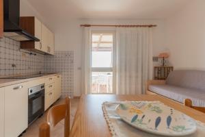 a kitchen and living room with a table and a table sidx sidx sidx at Appartamenti Belvedere by ElbaSummer in Lacona